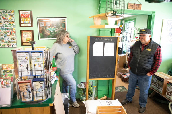  Maria Armanini speaks with a customer regarding a seed order while Robert Armanini listens in midday in March 2023. The Armanini's opened their birdseed store, Feed the Birds! in Croton-on-Hudson, New York, in 2010. Their business experienced a boom during the pandemic. Photo: Luke Franke/Audubon
